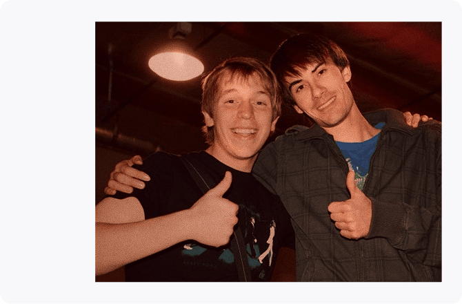 Aljoscha Zöller (rechts) mit einem Kollegen während seiner Zeit bei den Young Americans, beide lächeln in die Kamera und zeigen einen Daumen nach oben.